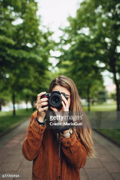 young woman taking a picture - foco no segundo plano stock pictures, royalty-free photos & images