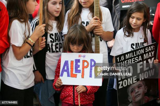 Children hold placards as they join a demonstration calling on the British government to take action to protect the children of the Syrian city of...