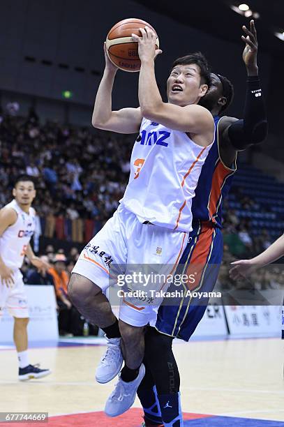 Shunki Hatakeyama of the Niigata Albirex BB tries to shoot under pressure from Faye Pape Mour of the Yokohama B-Corsairs during the B. League match...