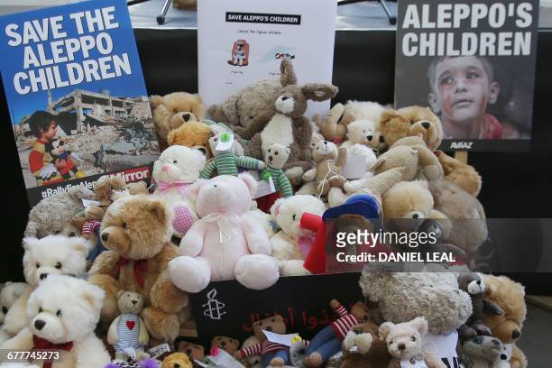 Pile of teddy bears nd placards are seen during a protest calling on the British government to take action to protect the children of the Syrian city...