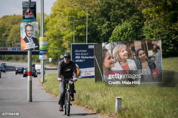 Man rides a bicycle past election campaign billboards of the German Social Democrats and the German Christian Democrats ahead of state elections in...