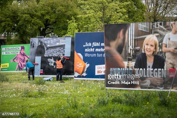 Workers stand near election campaign billboards of Free Democratic Party (Freie Demokratische Partei, or FDP, the German Social Democrats , the...