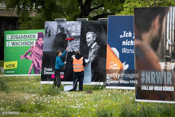 Workers stand near election campaign billboards of Free Democratic Party (Freie Demokratische Partei, or FDP, the German Social Democrats , the...