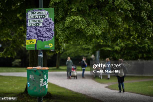 People walk near election campaign poster of German Greens Party ahead of state elections in North Rhine-Westphalia on May 3, 2017 in Duesseldorf,...