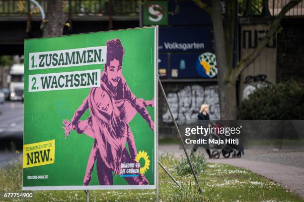 Woman walk past election campaign poster of German Greens Party ahead of state elections in North Rhine-Westphalia on May 3, 2017 in Duesseldorf,...