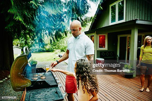 father cooking at backyard barbecue with daughter - american bbq stock pictures, royalty-free photos & images