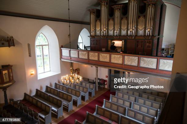 Organist playing inside Bronnoy Church, Bronnoysund, Nordland, Norway built in 1870.