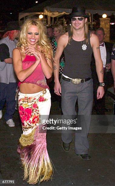 Actress Pamela Anderson, left, with her escort Kid Rock, right, enter the front gates of the Barnstable-Brown Derby Eve Gala May 4, 2001 in...