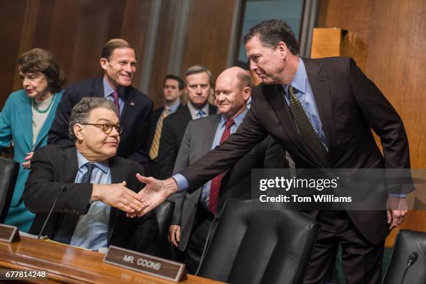 Director James Comey, right, greets Sen. Al Franken, D-Minn., upon arriving to testify before a Senate Judiciary Committee hearing in Dirksen...