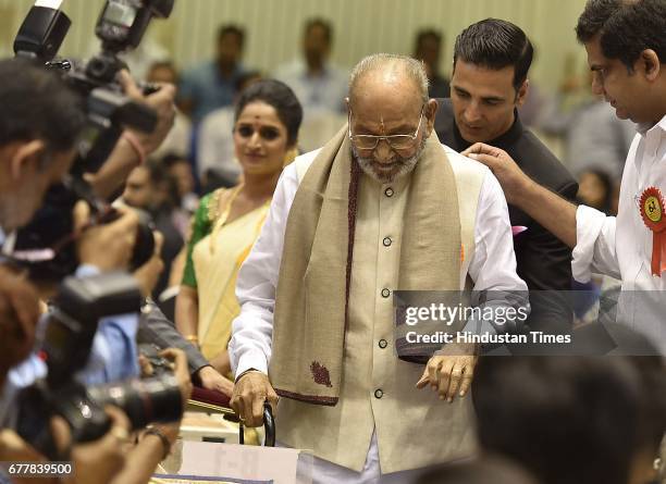 National winner in Best Actor category Akshay Kumar helps Dadasaheb Phalke lifetime Achievement Award winner Director K. Vishwanath during the 64th...