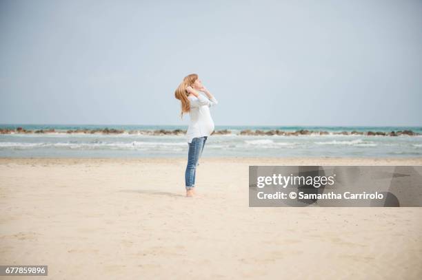 pregnant woman on the beach. casual clothes. - evasione dalla realtà fotografías e imágenes de stock