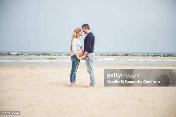 pregnant couple on the beach. hand in hand. casual clothes. - romanticismo 個照片及圖片檔