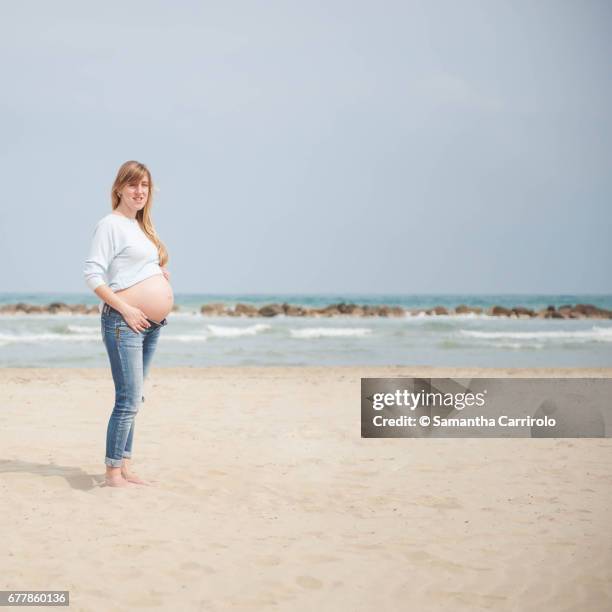 pregnant woman on the beach. casual clothes. nude abdomen. - ambientazione tranquilla stock pictures, royalty-free photos & images