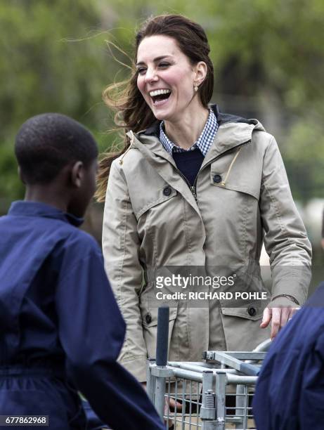 Britain's Catherine, Duchess of Cambridge jokes with children from London's Vauxhall Primary school following their attempt to herd a pig into a pen...