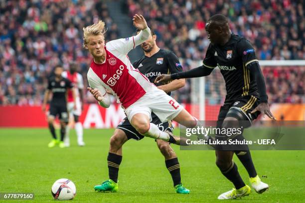 Kasper Dolberg of Amsterdam is attacked by Jeremy Morel and Nicolas Nkoulou of Lyon during the Uefa Europa League, semi final first leg match,...