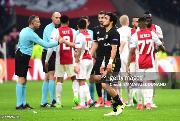 Ajax players celebrate the 4-1 victory as Lyon's Brazilian defender Rafael da Silva reacts after the UEFA Europa League semi-final, first leg, Ajax...