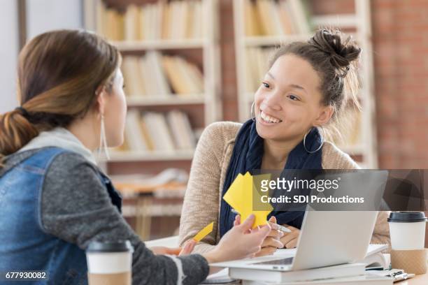 diverse female college students use notecards in campus library - flash card stock pictures, royalty-free photos & images