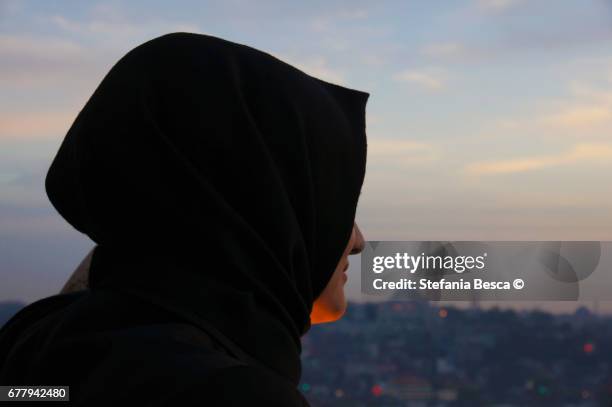 young woman with veiled head looks at the panorama - donne di età media stock-fotos und bilder