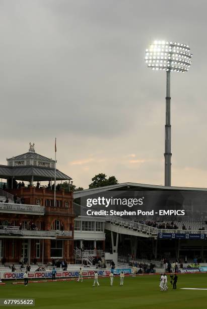 England's batsmen Alastair Cook and Kevin Pietersen leave the field at the close of play under floodlights