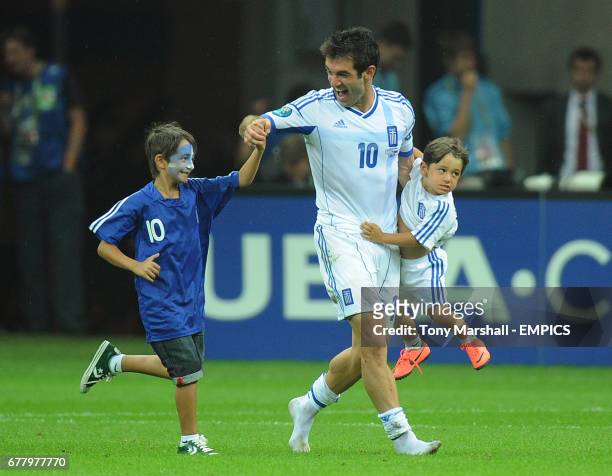 Greece's Giorgos Karagounis celebrates with his children after they qualify for the quarter finals of Euro 2012