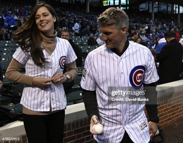 Former tennis player and French Open champion Ana Ivanovic tries on a Cubs jersey as her husband Chicago Fire Soccer player Bastian Schweinsteiger...