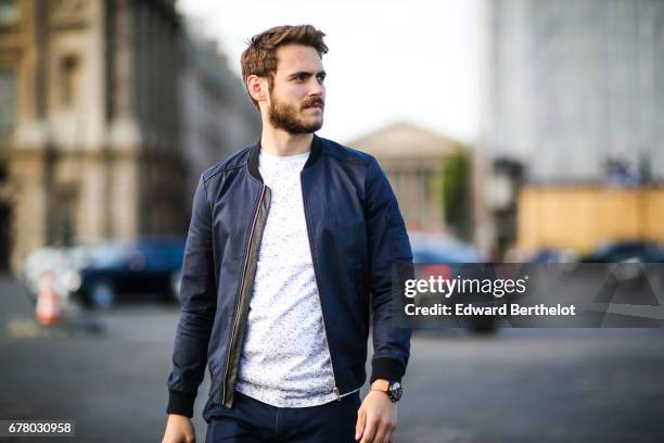 Kevin Ragonneau, fashion and life style blogger, wears a The Kooples bomber jacket, a Ted Baker t-shirt, Dockers chino pants, and Faguo shoes, at...