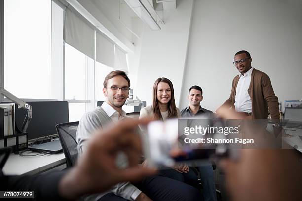 group of people posing for smart phone photo - fotoberichten stockfoto's en -beelden