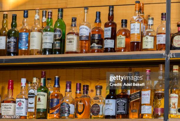 bottles with alcoholic in a bar - spiritueux photos et images de collection
