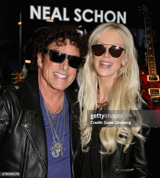 Guitarist Neal Schon of Journey and his wife, television personality Michaele Schon, attend a memorabilia case dedication for Neal Schon at the Hard...