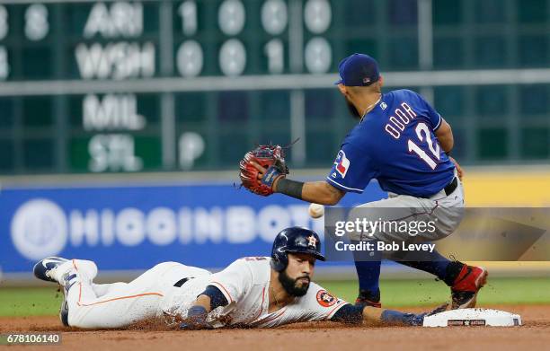 Marwin Gonzalez of the Houston Astros dives back into second base as Rougned Odor of the Texas Rangers can't handle the throw in the second inning at...