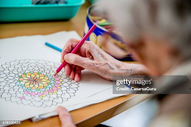 senior woman coloring mandala - coloring stock pictures, royalty-free photos & images