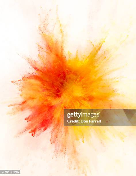 exploding colored powder - orange colour stock-fotos und bilder