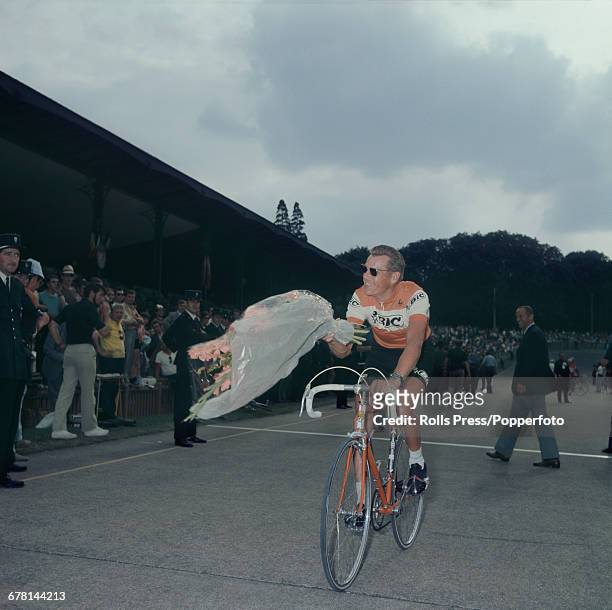 Dutch professional road race cyclist Jan Janssen pictured cycling with a large bouquet of flowers after finishing in tenth place after completing the...