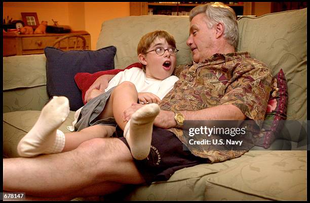 Author John Irving sits on the couch with his youngest son Everett, June 27, 2001 in his home in Vernon, Vermont.