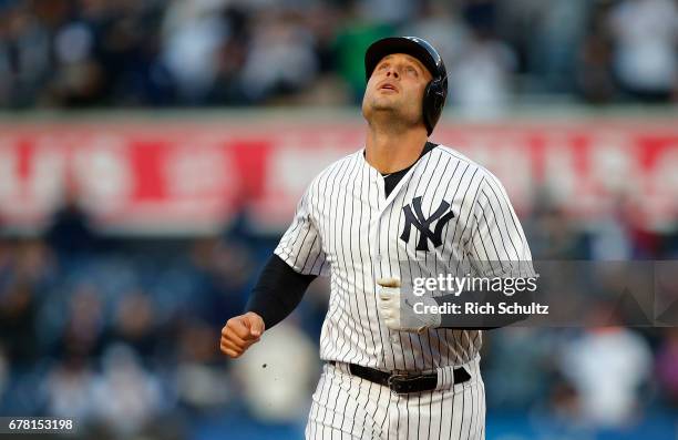 Matt Holliday of the New York Yankees looks to the sky as he rounds the bases after hitting a three-run home run in the first inning against the...