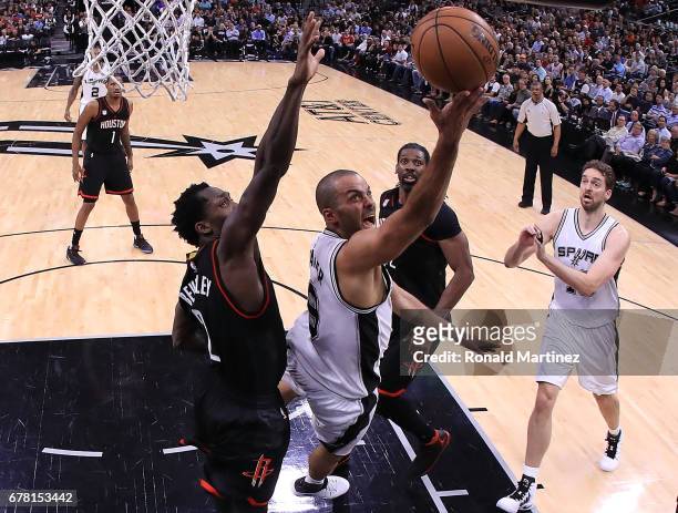 Tony Parker of the San Antonio Spurs drives against Patrick Beverley and Nene Hilario of the Houston Rockets during Game Two of the NBA Western...