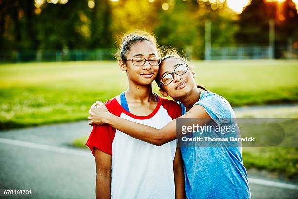 Twin sisters embracing on basketball court