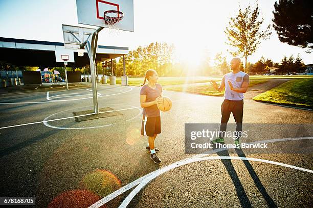 father teaching daughter on basketball court - streetball stock pictures, royalty-free photos & images