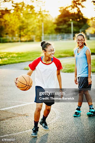 Young woman playing basketball with sister