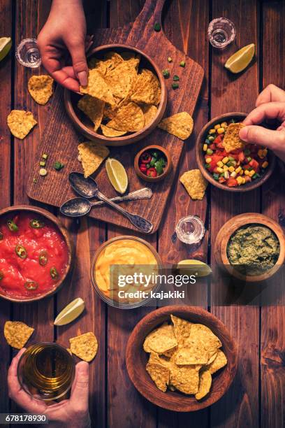 family eating nachos with sauces - family eating potato chips stock pictures, royalty-free photos & images