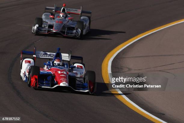 Carlos Munoz of Colombia, driver of the A.J. Foyt Enterprises Chevrolet and Will Power of Australia, driver of the Team Penske Chevrolet drive during...