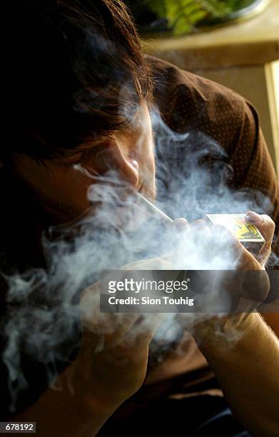 Man smokes marijuana at his home August 8, 2001 in the Dalston section of East London. British medical experts cleared the drug March 14, 2002 for...