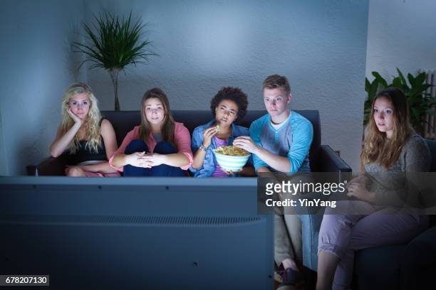 groep van tiener meisjes en jongens kijken samen voor een tv - boy at television stockfoto's en -beelden