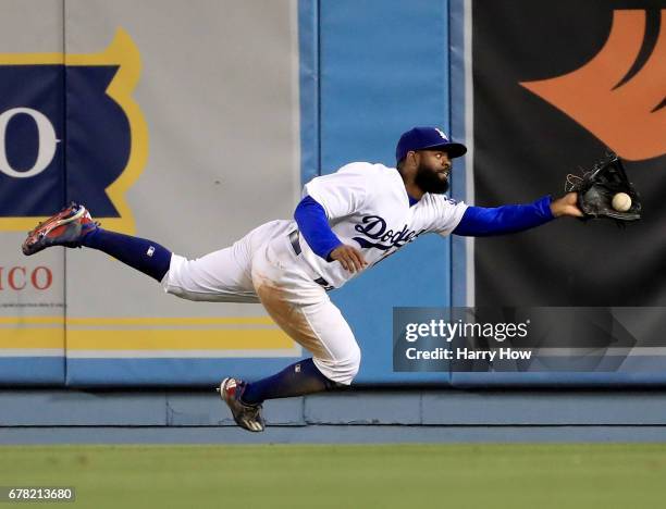 Andrew Toles of the Los Angeles Dodgers makes a running catch for an out of Hunter Pence of the San Francisco Giants during the 11th inning at Dodger...