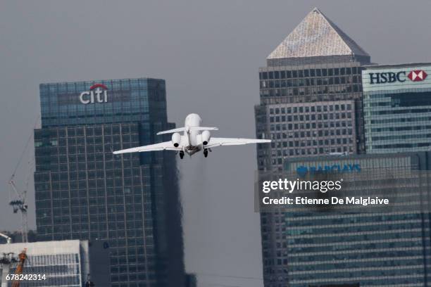 Business jet takes off from the London City Airport - LCY and climbs over Canary Wharf financial district, on April 20, 2017 in London, England.