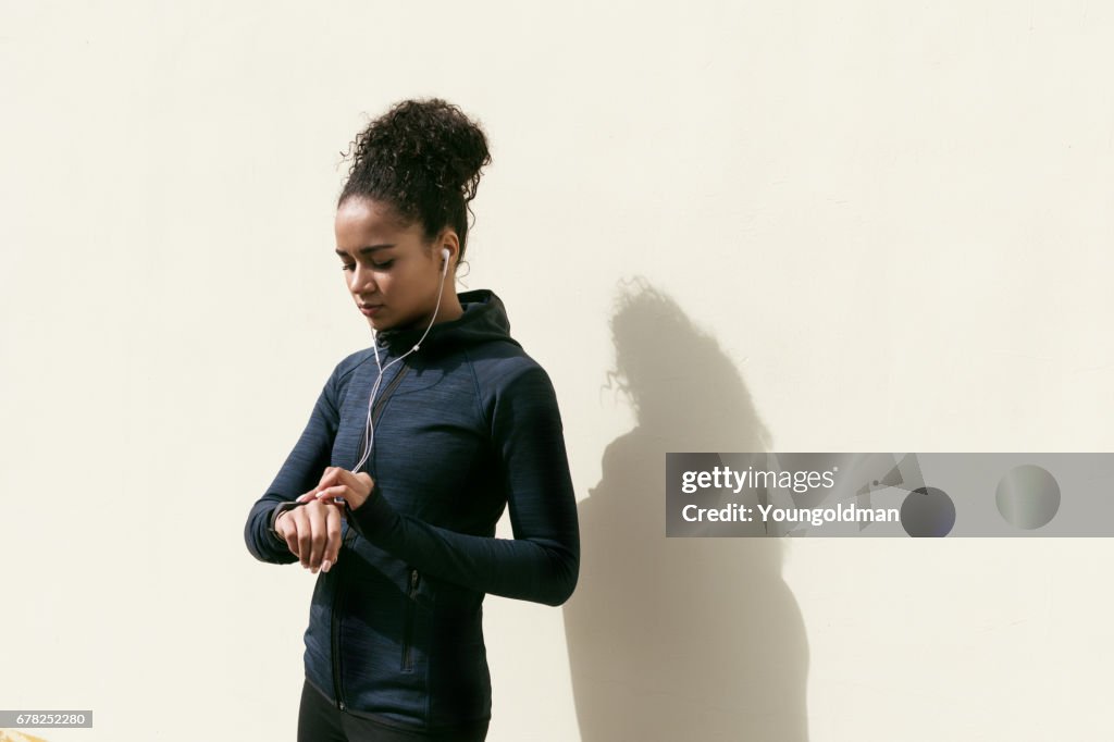 Young woman checking activity tracker on her wrist