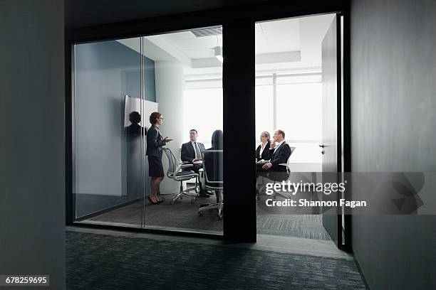 businesswoman leading group meeting in office - toned image stock pictures, royalty-free photos & images