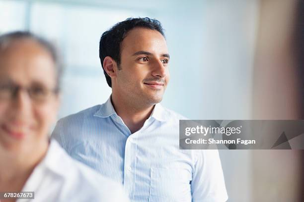 young man looking sideways towards office window - man woman wondering stock pictures, royalty-free photos & images