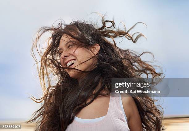 girl enjoying wind in her hair while moving - visage caché par les cheveux photos et images de collection
