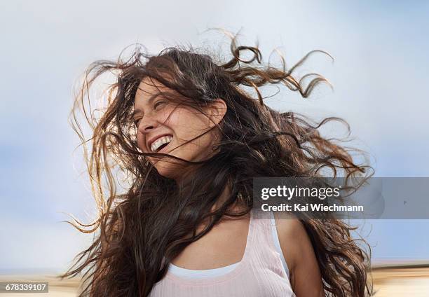 girl enjoying wind in her hair while moving - wavy brown hair stock pictures, royalty-free photos & images